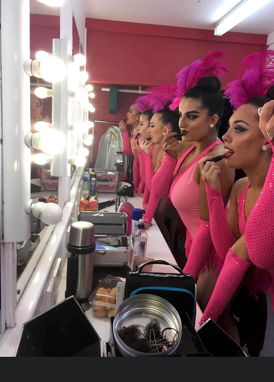Libby and other JL dancers getting ready backstage in pink costumes