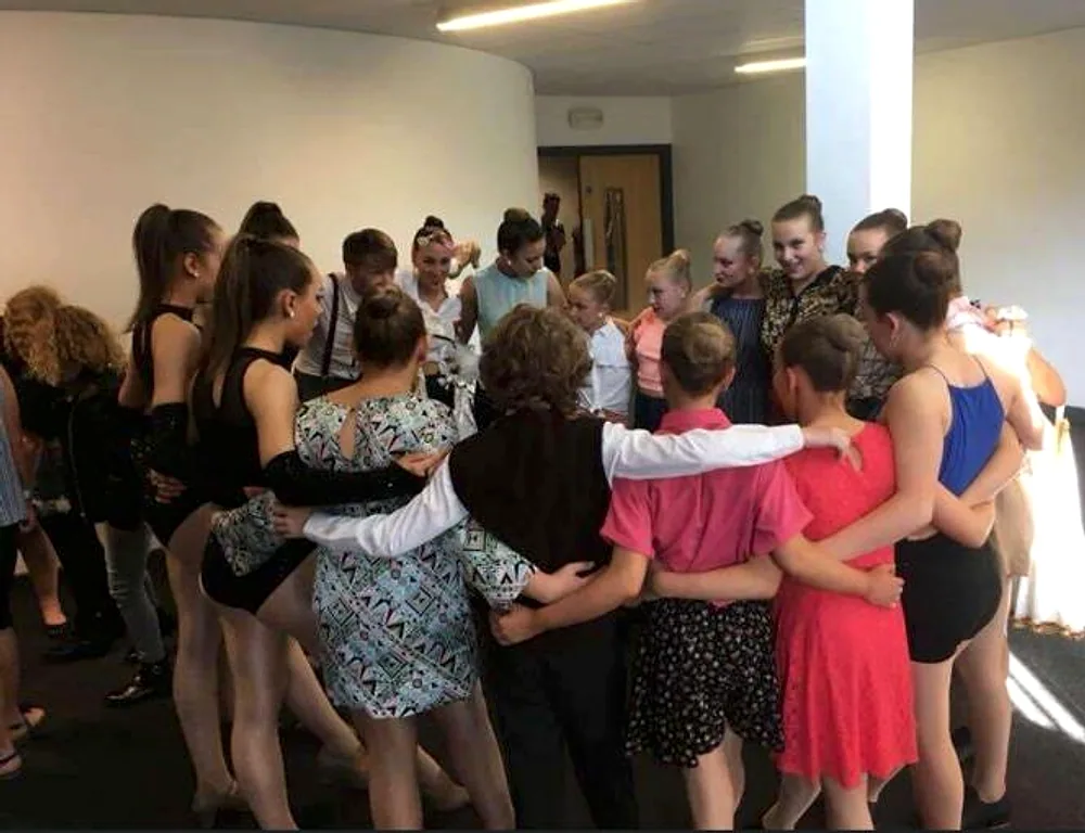 JL Dance dancers standing together in a team huddle